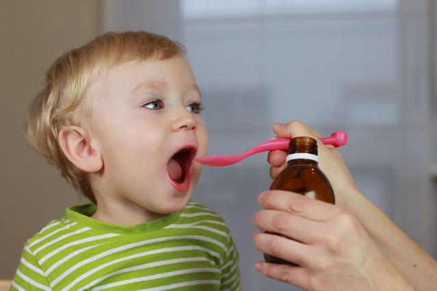 Ребенок принимает сироп от сильного кашля